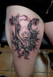 Kuh Tattoo mit Blumen